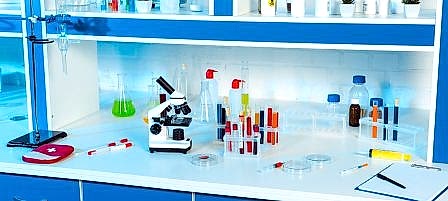 flasks, test tubes and bottles near microscope in modern laboratory